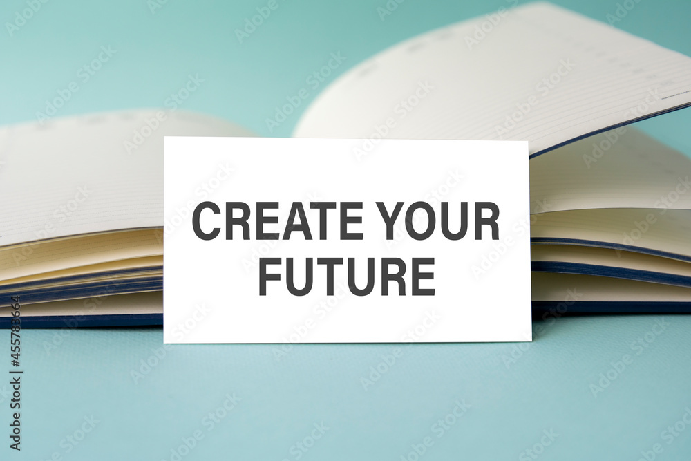 Aufkleber a white business card with create your future text stands on a desk against the background of an ope