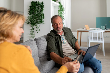 Senior couple relaxing sitting on the sofa at home