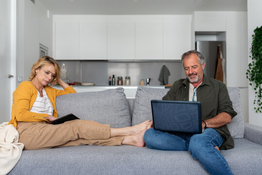 Senior Couple Relaxing Sitting On The Sofa At Home