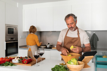 Mature man peeling vegetables at kitchen
