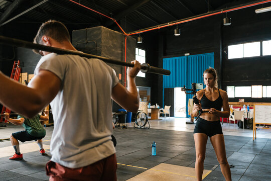 Female athlete recording video for fitness blog