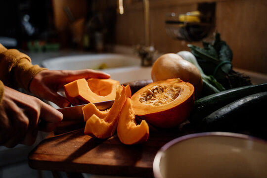 Man slicing pumpking on cutting board