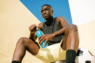 Black football player resting during training