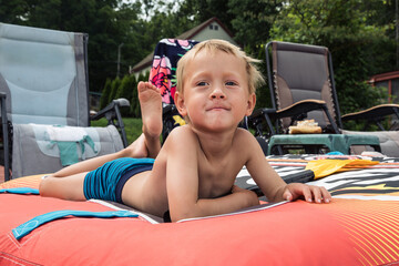 Little boy laying on a floaty on a deck