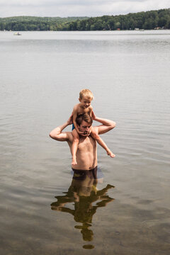 Dad carrying his son on his shoulders in the water