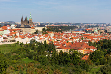 Fototapeta premium Autumn Prague City with gothic Castle and the colorful Nature with Trees from the Hill Petrin, Czech Republic