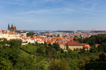 Fototapeta premium Autumn Prague City with gothic Castle and the colorful Nature with Trees from the Hill Petrin, Czech Republic