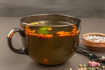 Transparent chicken broth with vegetables in a cup