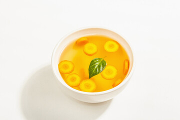Transparent chicken broth with vegetables in ceramic bowls