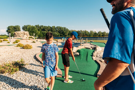 Father and sons golfing. 