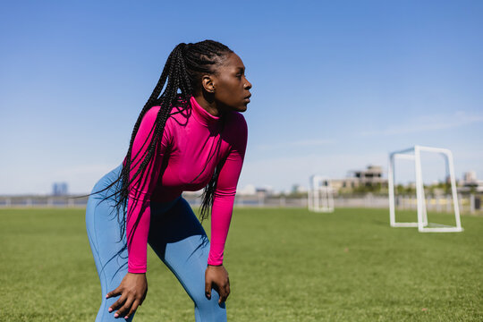 Black fit woman standing on sports field 