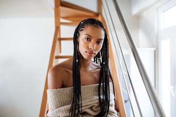 Woman with braided long hair sitting in the bed