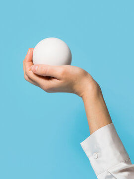 Female hand holding a white ball