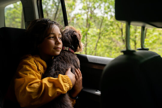 Little kid traveling by car accompanied by his dog