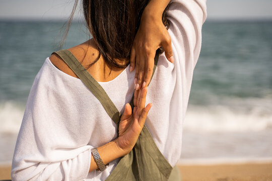 Detail of woman stretching doing yoga at beach