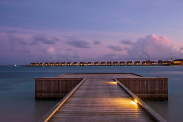 Obraz premium hard rock hotel pier end on a turquoise water at sunset time. Crossroads Maldives, july 2021