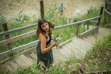 cheerful young girl spending good time at the beach. Beauty portrait. Сute teenage girl or woman on the beach nature landscape fresh air beach. Natural beauty. lifestyle/ real people/ funny/ dance.