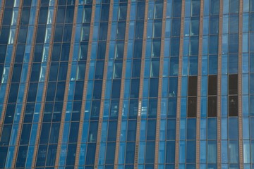 blue colored glass facade of a tall high rise building in Vienna in close up