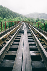 Fototapeta na wymiar The length of the railway track on a bridge in mountains
