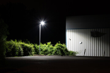 A minimal design of a street light next to a modern factory 
