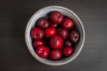 Fresh ripe cherries in a cup on a wooden background. Dessert. Healthy eating. Vegetarian breakfast.