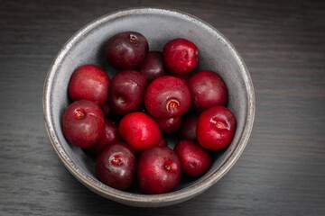 Fresh ripe cherries in a cup on a wooden background. Healthy eating. Dessert. Vegetarian breakfast.