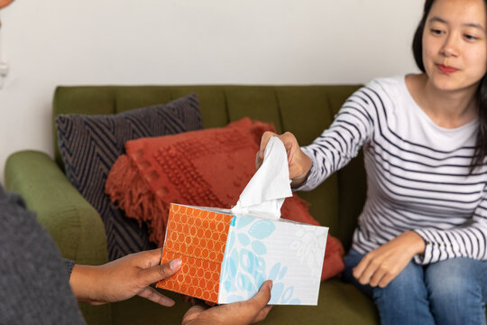Woman Holds Out Tissue Box to Friend