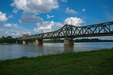 Fototapeta na wymiar railroad bridge across the Danube river in Vienna on a sunny cloud sky day