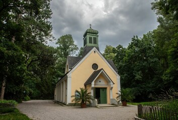 small pilgrimage church in a remote location of the Vienna prater park with storm clouds