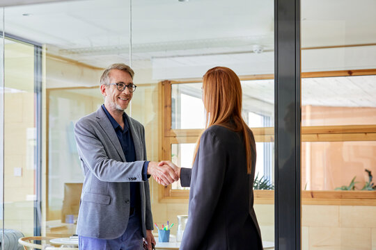 Senior businessman greeting businesswoman