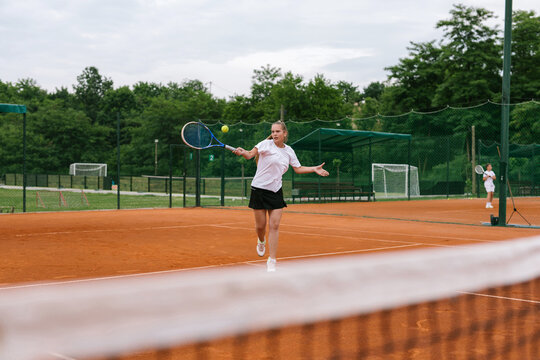 Young tennis player on the outdoor court. 