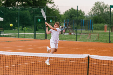 Young tennis player on the outdoor court. 