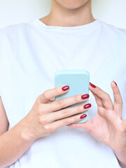 Woman hands holding a smart phone, white background with copy space.