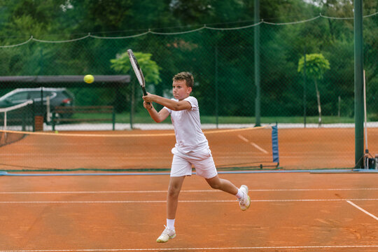 Young tennis player on the outdoor court. 