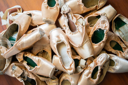 Used Ballet Pointe Shoes Of A Ballerina On The Floor.