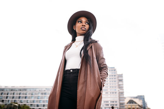 Serious black woman in leather coat and hat