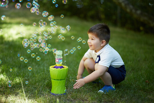 Boy Playing With A Bubble Machine