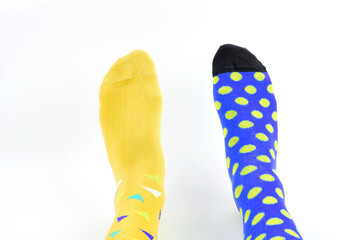 Legs with different a pair of mismatched socks on white background. World Down syndrome day background. Down syndrome awareness concept. Copy space.