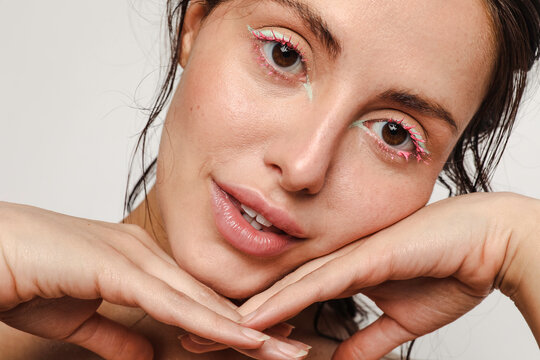 Young woman with green eyeliner and pink mascara