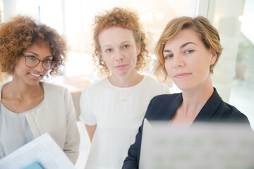 Three office workers talking at office