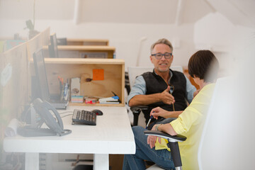 Man and woman sitting in office and talking