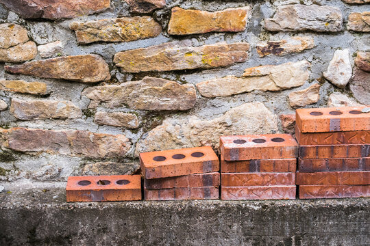 bricks in front of stone wall