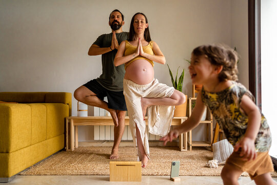 Couple practicing yoga together at home