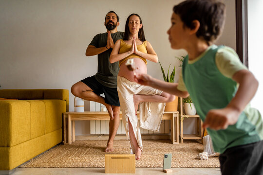 Parents practicing yoga together at home