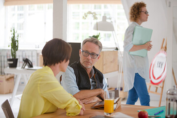 Obraz premium Man and woman sitting in office,smiling and talking