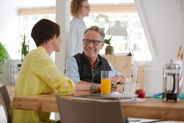 Man and woman sitting in office,smiling and talking