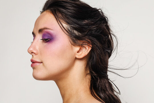 Beautiful woman with purple makeup on 
