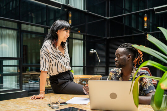 Girl Sitting On The Table And Chatting In The Office. - Powered by Adobe