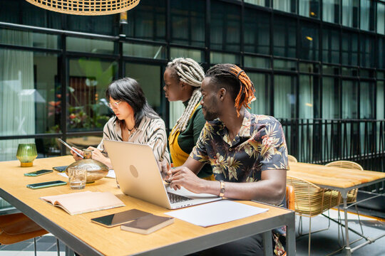 People Sitting Around The Table At Work In A Coworking.