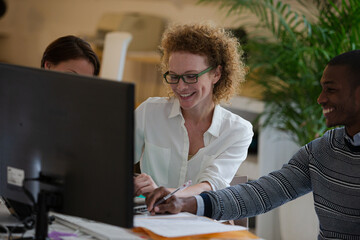 Fototapeta premium Office workers talking over computer at desk